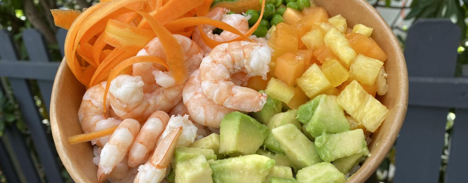 Bol de riz avec crevettes, avocat, carottes et fruits.